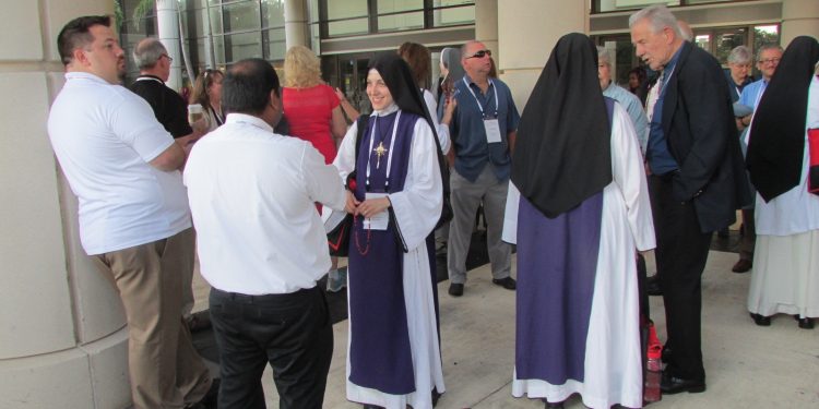 Local Children of Mary Sisters meet others waiting for the Eucharistic procession to begin (CT Photo/Gail Finke)