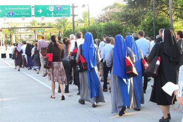 Hundreds of people fanned out on the pavement at the beginning of the Eucharistic procession route, kneeling when the procession passed them and then standing to join in until all the participants were walking the one-mile route. (CT Photo/Gail Finke)