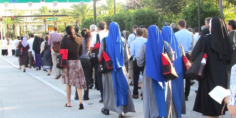 Hundreds of people fanned out on the pavement at the beginning of the Eucharistic procession route, kneeling when the procession passed them and then standing to join in until all the participants were walking the one-mile route. (CT Photo/Gail Finke)