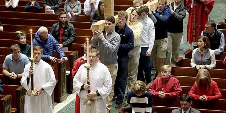 Students from Cincinnati Moeller High School carry the Holy Cross for the Celebration of the Passion of the Lord at the Cathedral of St. Peter in Chains in Cincinnati on Good Friday, Mar. 30, 2018. (CT Photo/E.L. Hubbard)