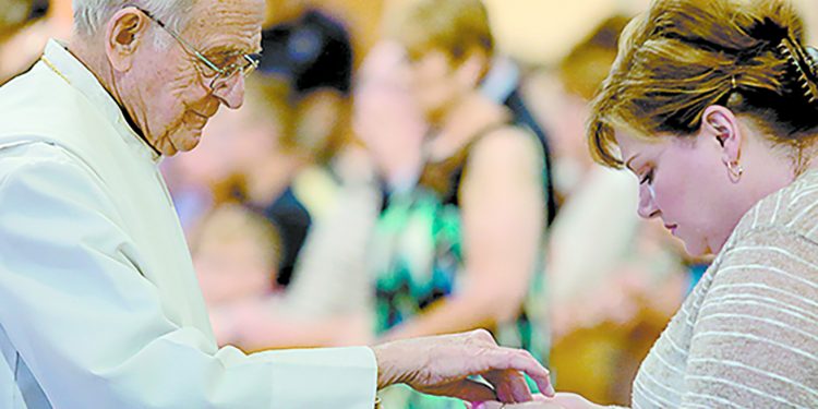 Father William Dorrmann delivers the Holy Eucharist to a parishioner during the St. Aloysius Parish 150th Anniversary Mass in Shandon Saturday, June 2, 2018. (CT Photo/E.L. Hubbard)