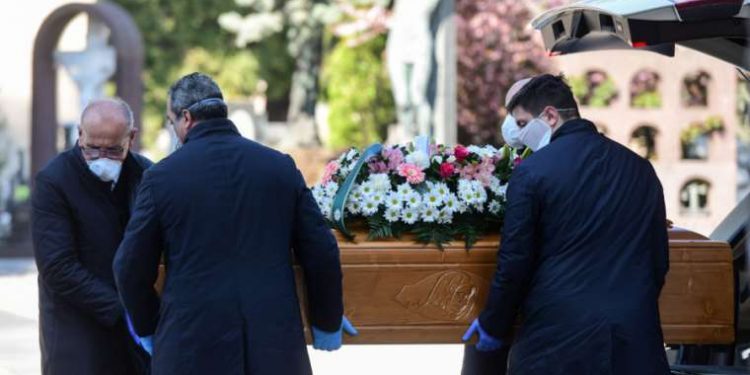 Undertakers wearing face masks carry a coffin in a cemetery in Bergamo, Italy, March 16, 2020. Credit: AFP via Getty Images